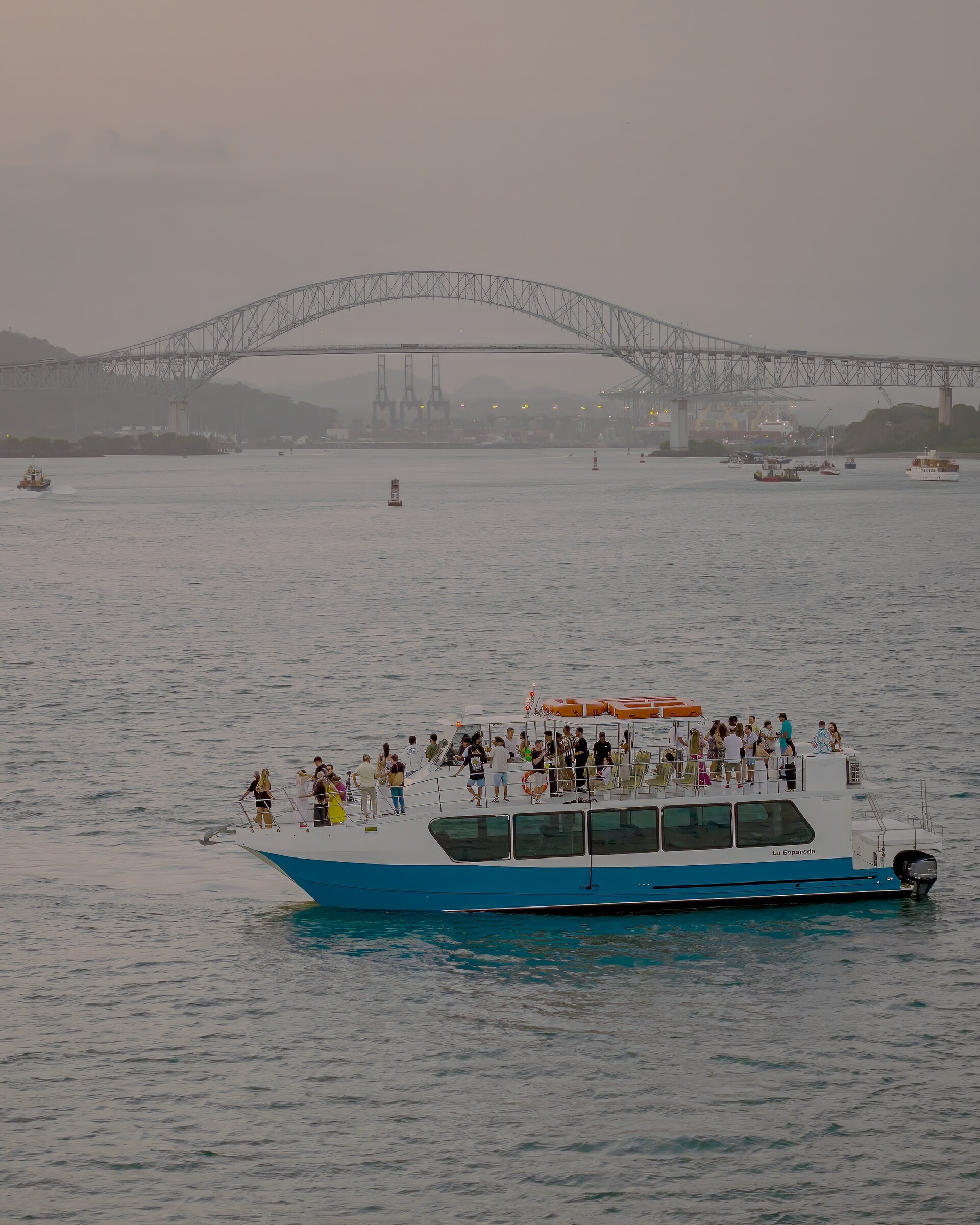 Grupo a bordo en la cubierta superior con el skyline de fondo, hora dorada