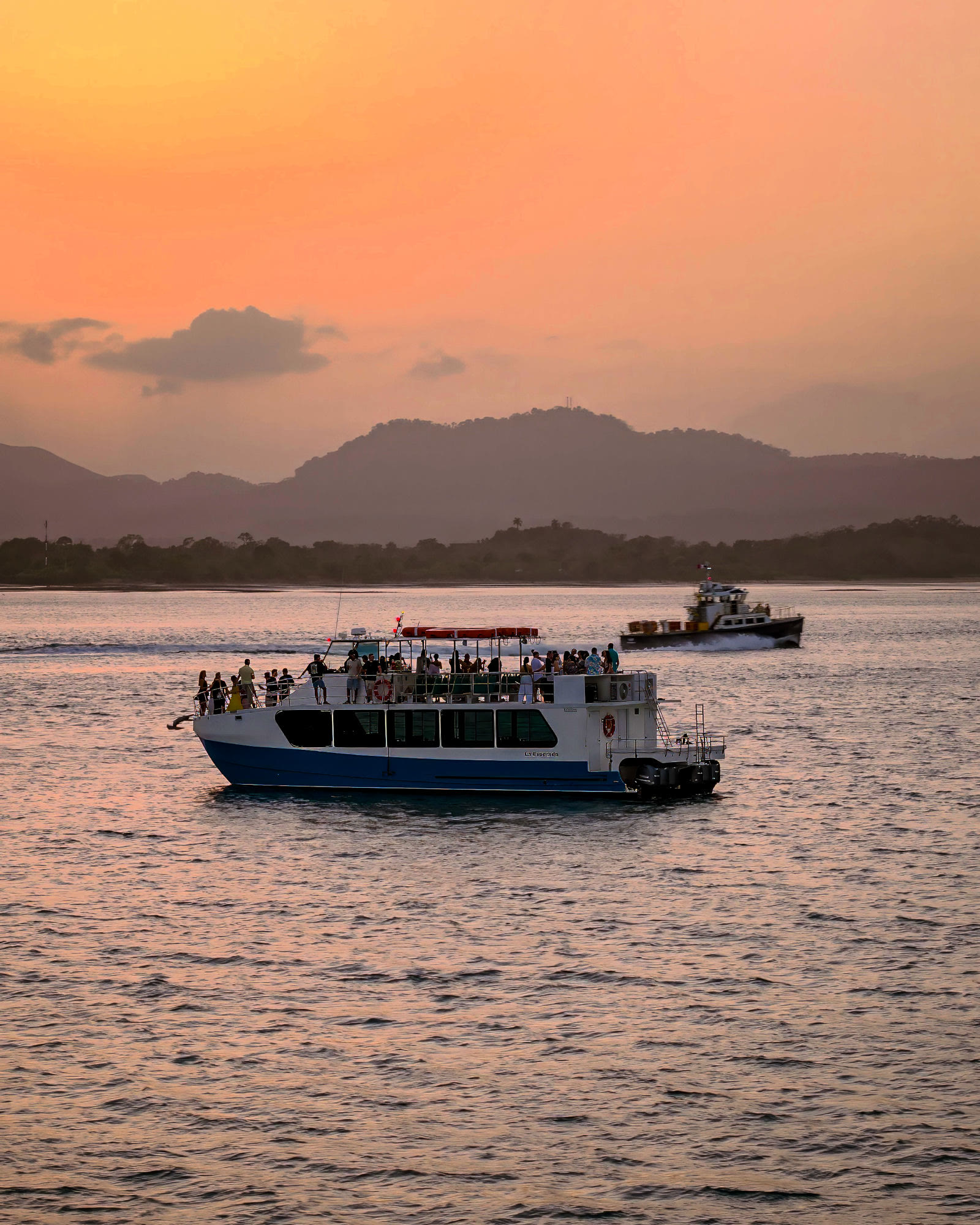 El catamarán al atardecer, cielo naranja sobre la bahía